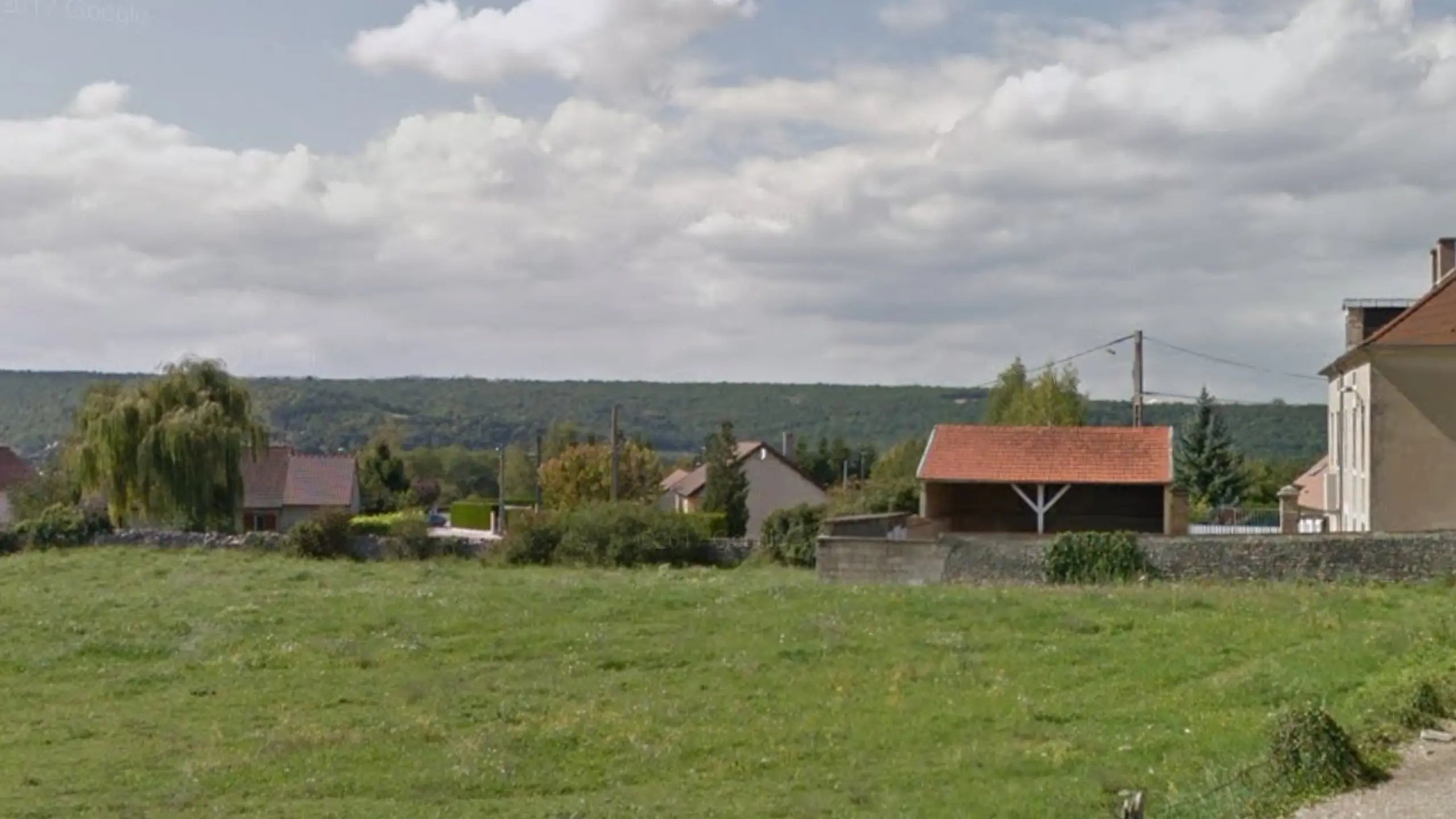 Vue Street View d’un village de la Côte-d’Or, avec une colline boisée à l’horizon